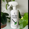 White spray bottle labeled 'Elm Dirt Sword' with green leaves in the background