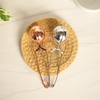 Two tea infusers, one copper and one silver, on a woven mat.