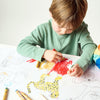 Child coloring a picture of a leopard with crayons on a white sheet of paper.