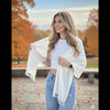 Woman holding a white scarf in an autumn park