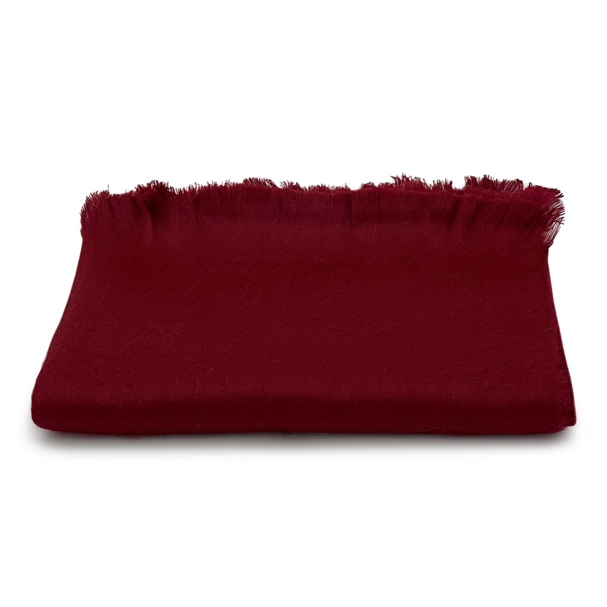 Red blanket with frayed edges on a white background