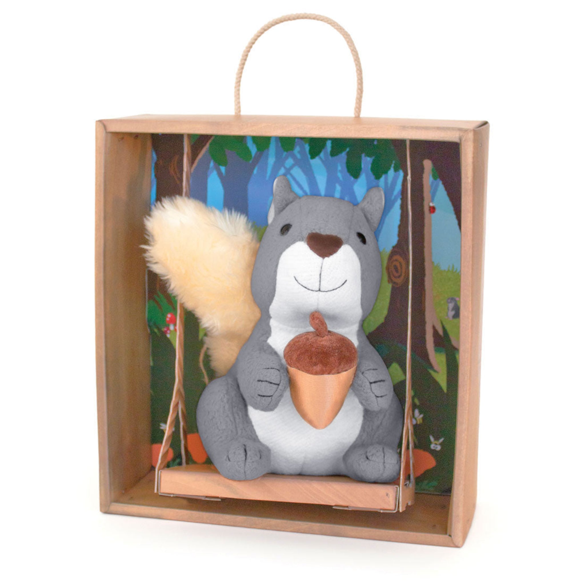Plush squirrel toy in a wooden gift box with a forest scene background