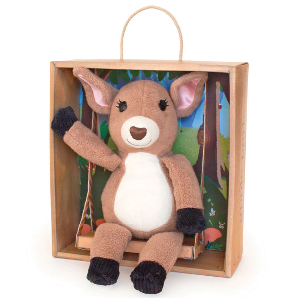 Plush deer toy in a wooden box with a colorful background