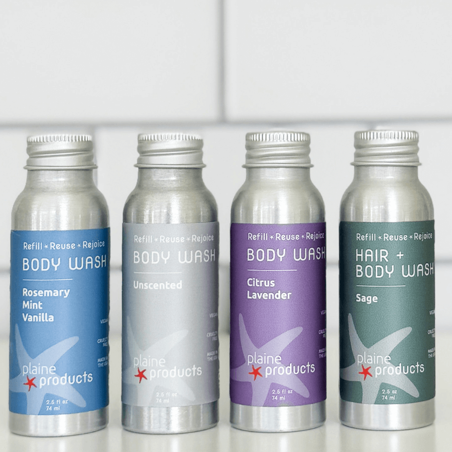Close-up of Plaine Products reusable travel size body wash bottle in aluminum with pump