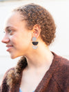 Model wearing Fair Anita dark half moon stacked earrings styled with a casual everyday outfit