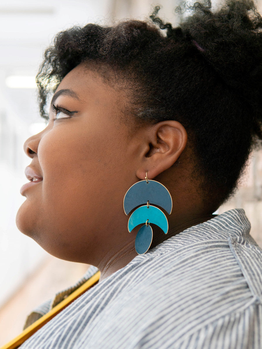 Model wearing Fair Anita dark matte blue statement earrings showing full drop length of 3.25 inches