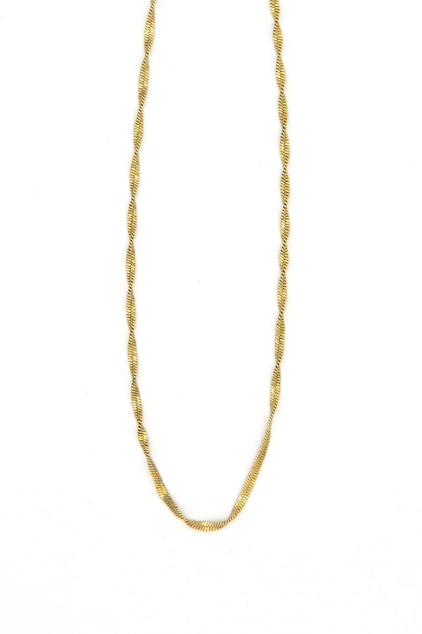 Flat lay of twisted snake chain necklace in gold and silver options on neutral background