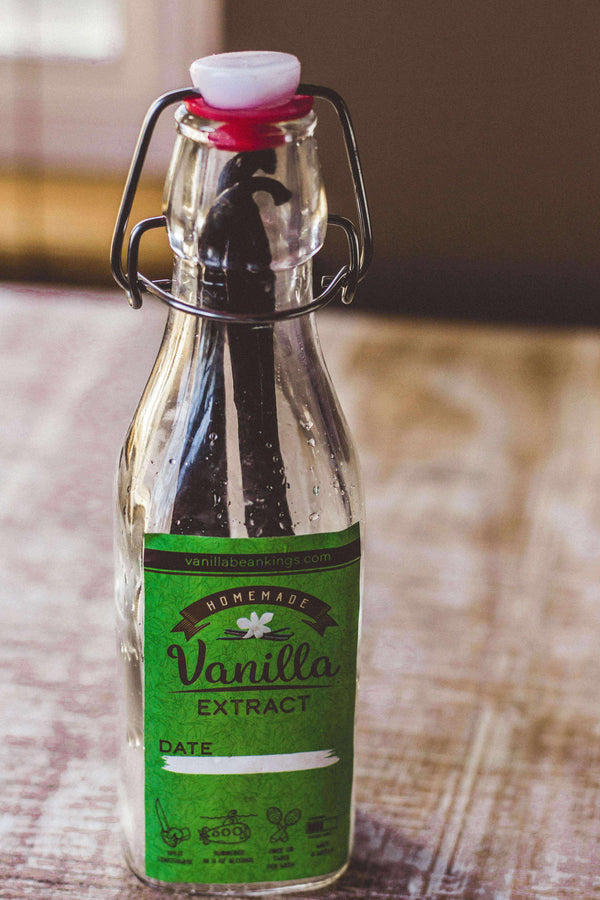 Bottle of homemade vanilla extract on a wooden surface