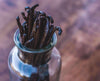 Vanilla beans in a glass bottle with a blurred background