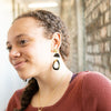 Fair Anita upcycled horn statement earrings displayed flat, showing oval shape and warm tones