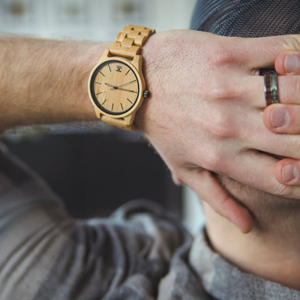 Person wearing a wooden watch with a blurred background