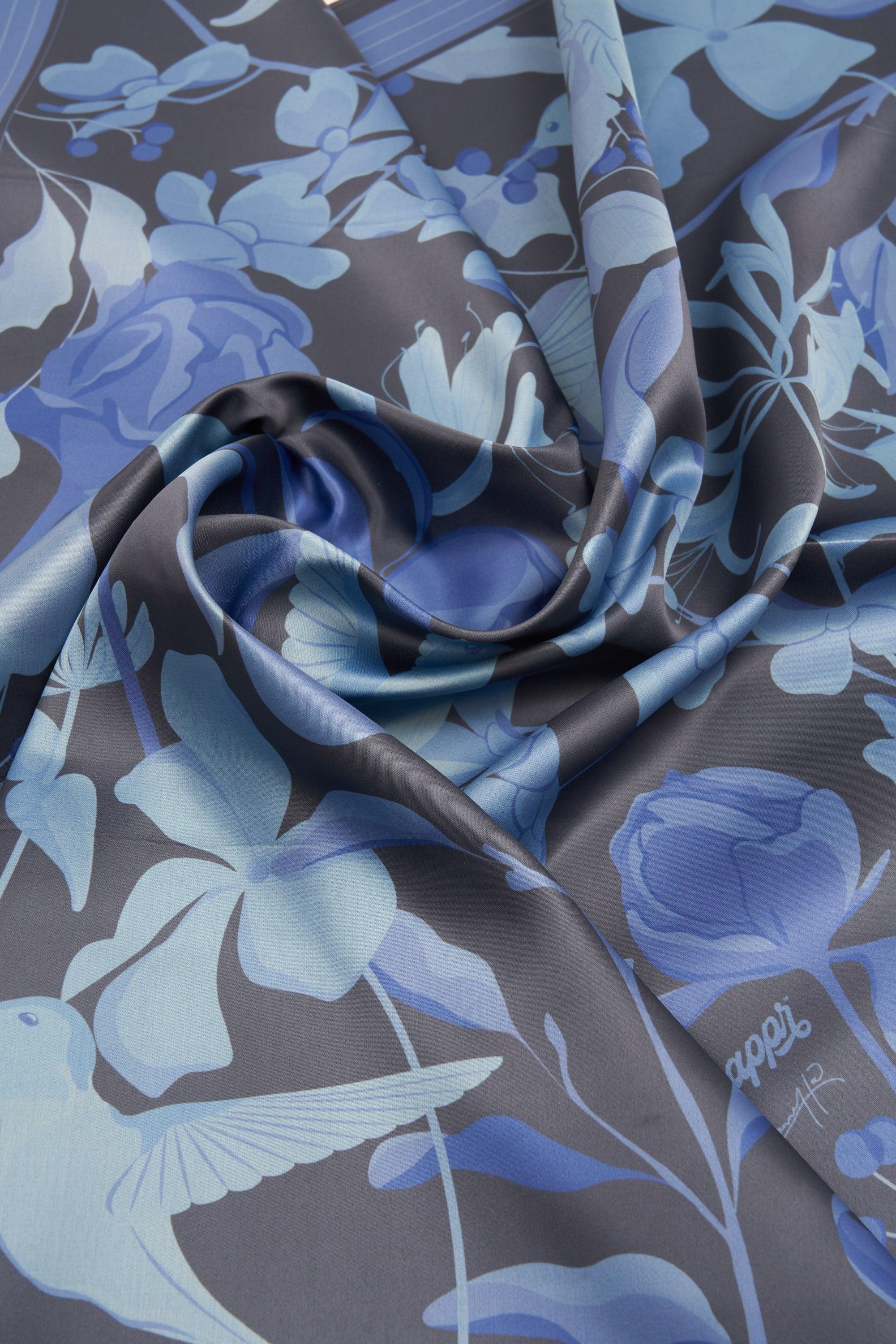 Blue floral and bird patterned fabric with a visible brand label.
