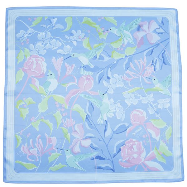 Floral and hummingbird patterned fabric square on a light blue background