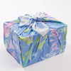 Gift wrapped in colorful paper with a bow on a white background