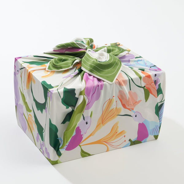 Square box wrapped in colorful floral paper on a white background
