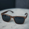 Walnut Wayfinder unisex wooden sunglasses with American walnut frames on a flat lay surface