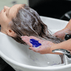 Person washing hair with purple toning shampoo to remove brassiness