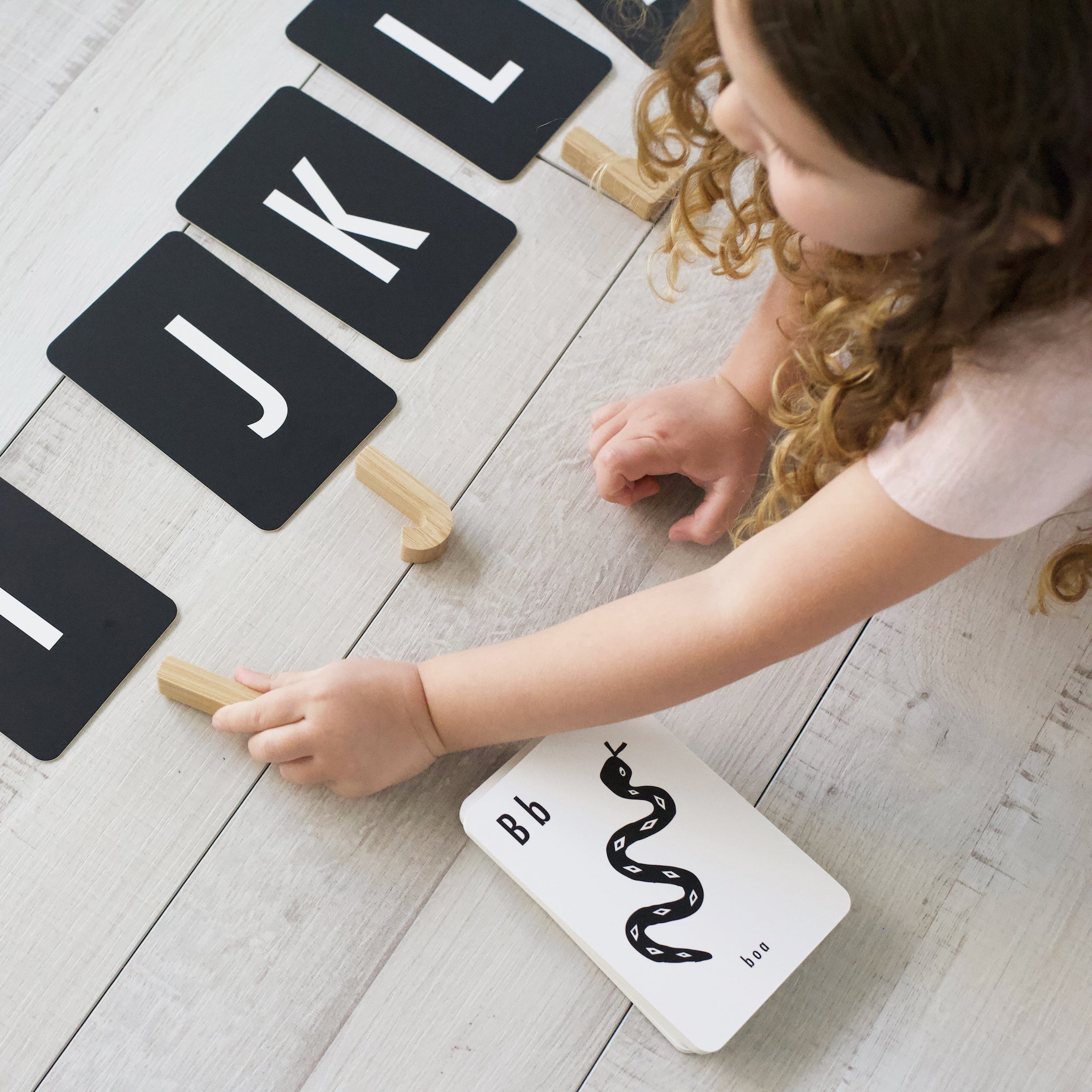 Wee Gallery bamboo alphabet set paired with animal learning cards on a play surface