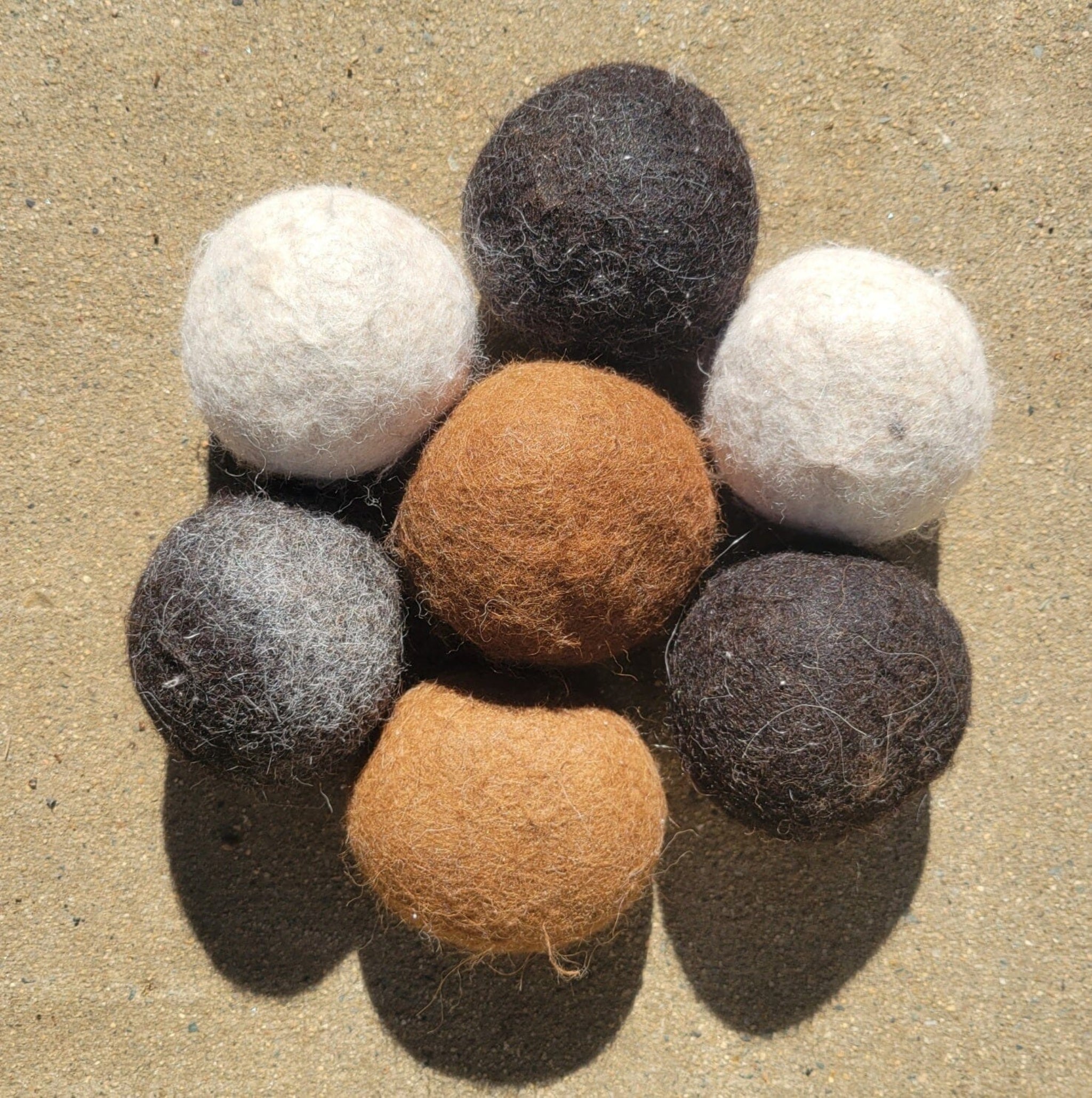 Set of felt balls in various colors on a textured surface