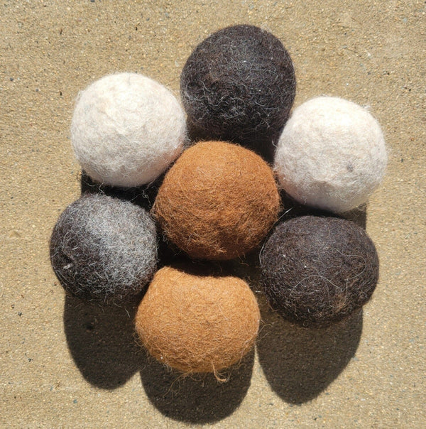 Set of felt balls in various colors on a textured surface