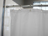 White shower curtain with silver hooks on a rod in a bathroom setting.