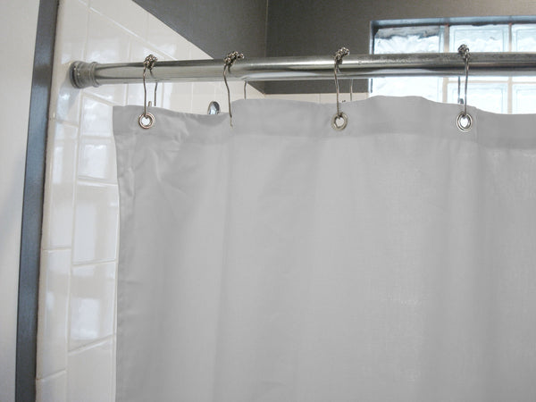 White shower curtain with silver hooks on a rod in a bathroom setting.