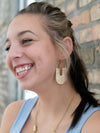 Fair Anita white woven hoop earrings styled on model – natural raffia statement earrings