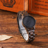 Wooden watch with black face on a wooden surface