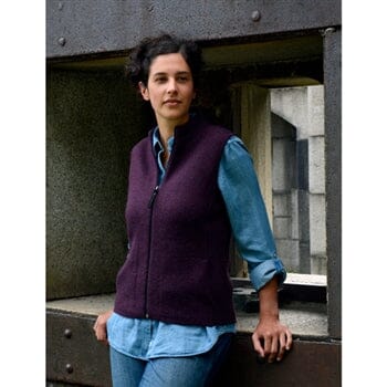 Person wearing a purple vest over a blue shirt in an urban setting