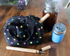 Black polka dot bag with wooden items on a wooden table