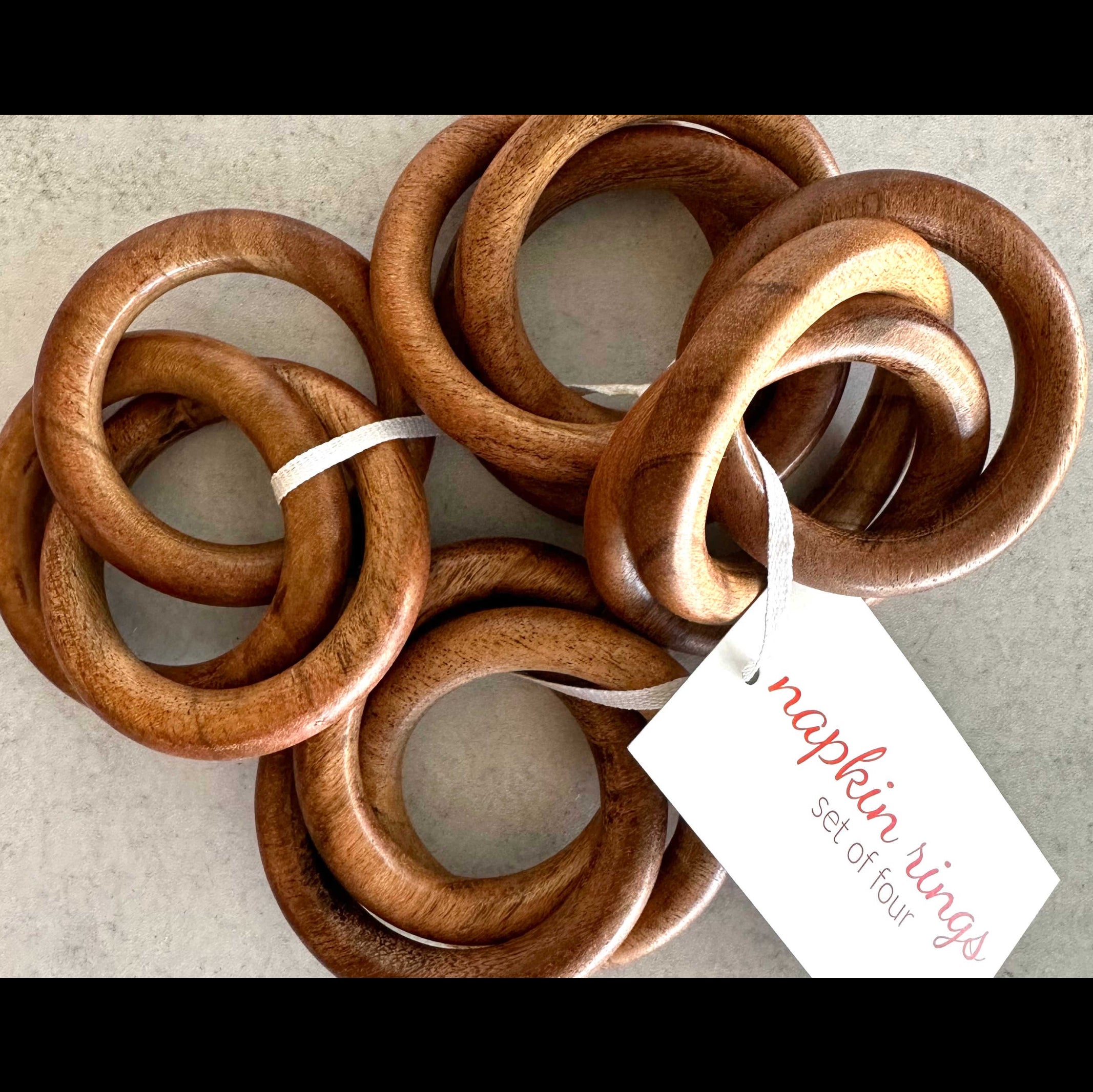 Set of three natural wood bangle napkin rings on a white surface