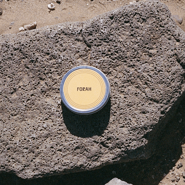 Candle labeled 'FORAH' on a rocky surface