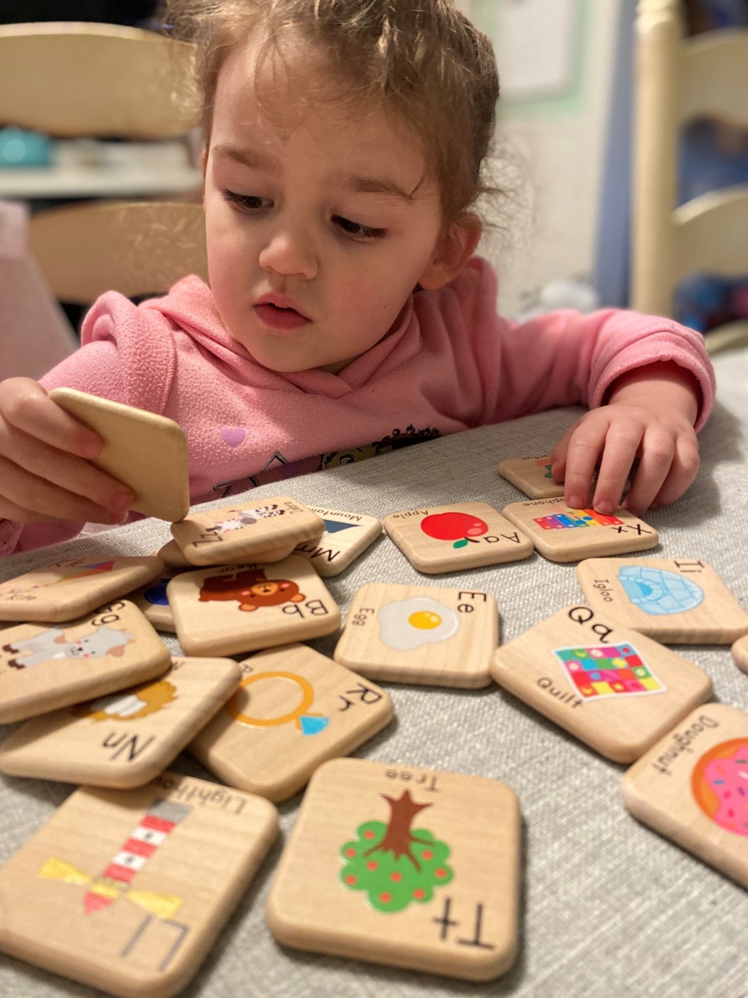 A picture of a child playing with the ABC Learning Tiles, learning the alphabet and having fun.