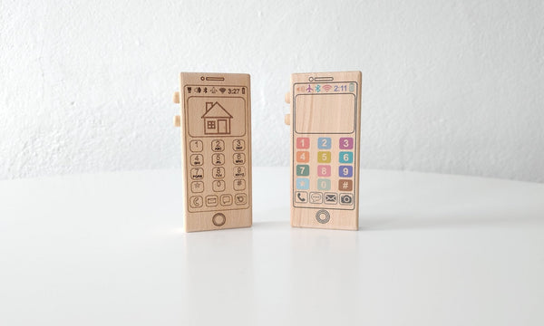 A close-up of the numbers and letters on the colorful wooden toy phone. The numbers and letters are painted in bright colors, and they are easy to read and identify. The phone is made of maple wood, and it has a smooth, rounded shape.