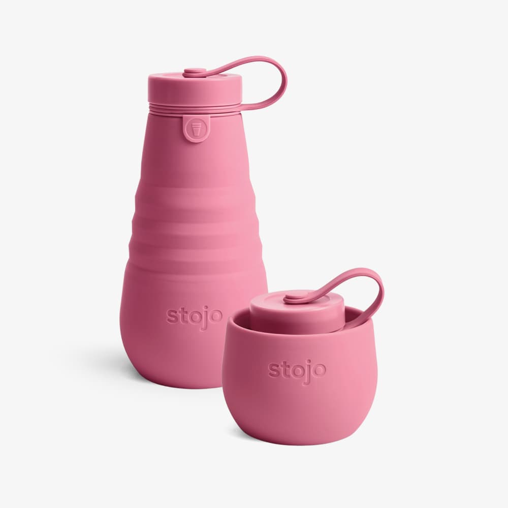 A peony collapsible water bottle made by Stojo. The bottle is made of silicone and has a peony silicone loop on the top. The bottle is collapsed in the picture, but it can be expanded to hold 20 ounces of water.