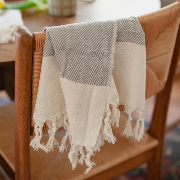 These Herringbone Turkish Hand Towels are highly absorbent and dry faster than traditional towels. Made from 100% Turkish cotton and artfully hand-knotted in Turkey, they become softer and fluffier over time. They are machine washable and made with sustainable, natural fibers and non-toxic dyes. The tassels are hand-knotted by women in their homes, adding a personal touch. Perfect for refreshing any kitchen or bathroom.